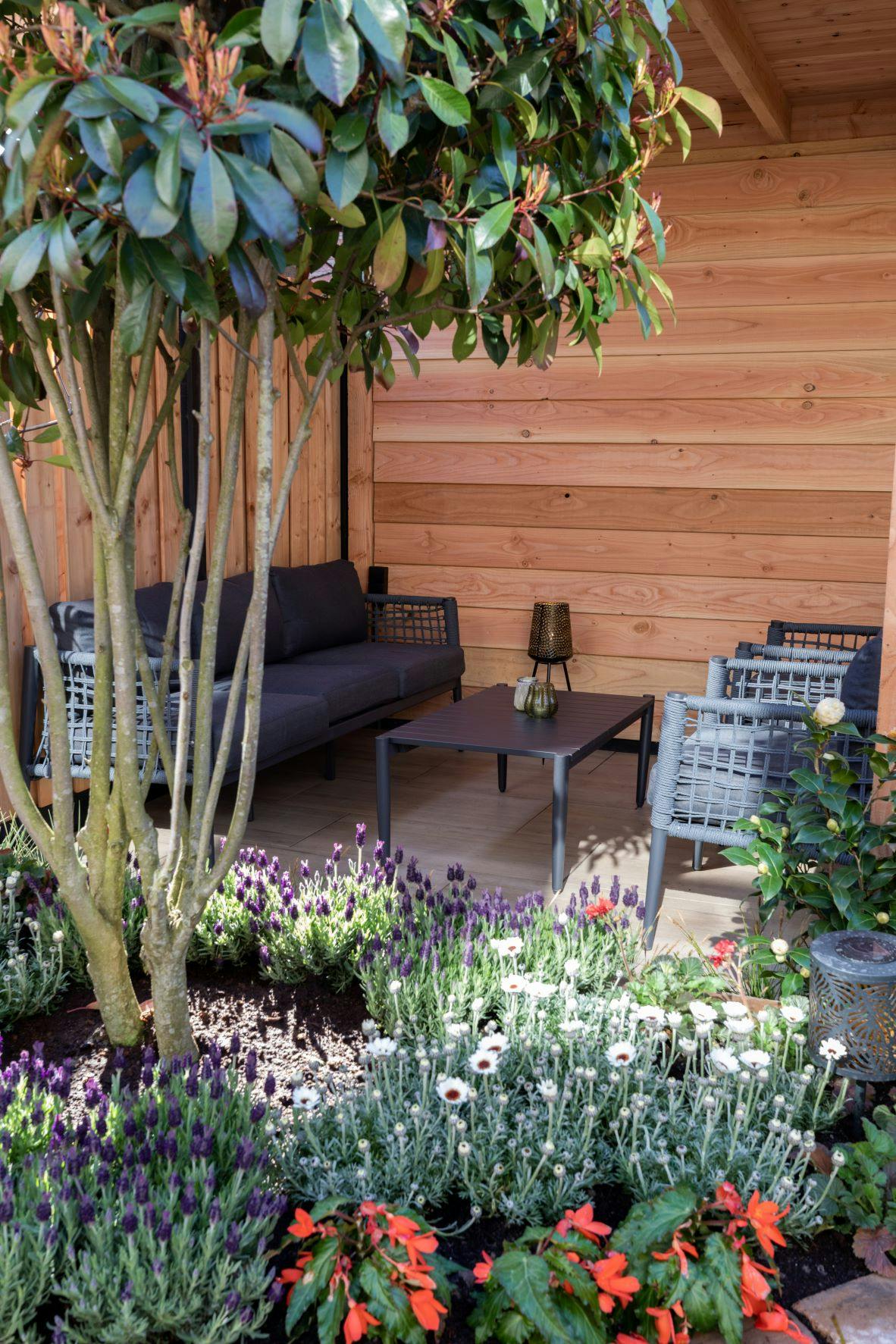 Tuin overkapping NuBuiten Westwood buitenverblijf fijnbezaagd bloemen